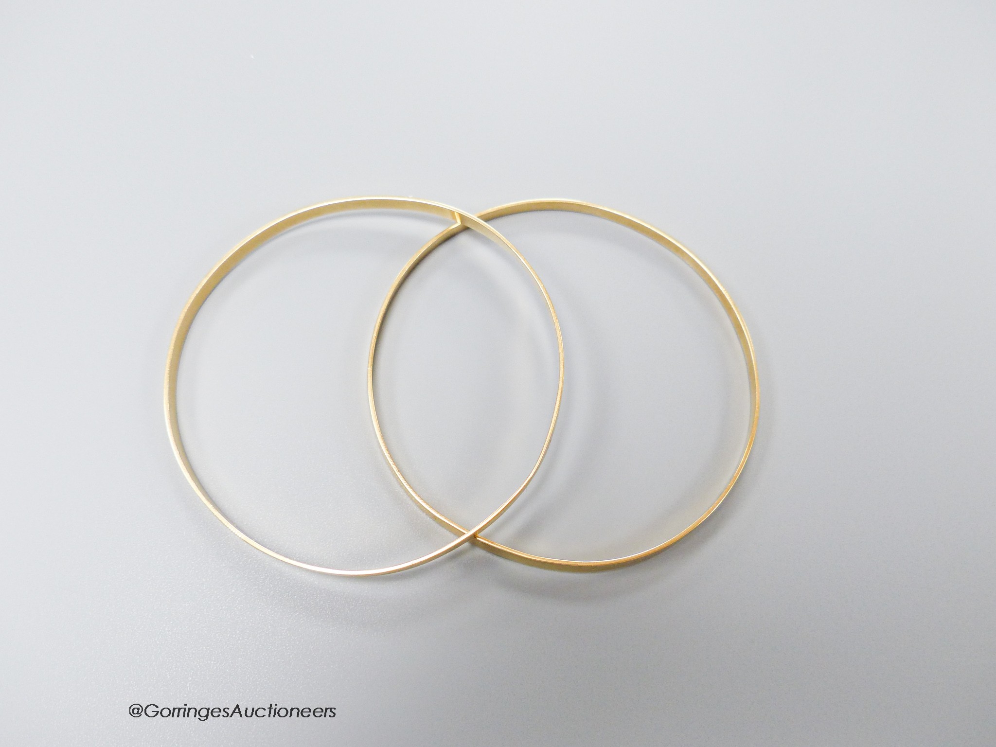 A pair of yellow metal bangles, stamped 18k, gross 18.1 grams.